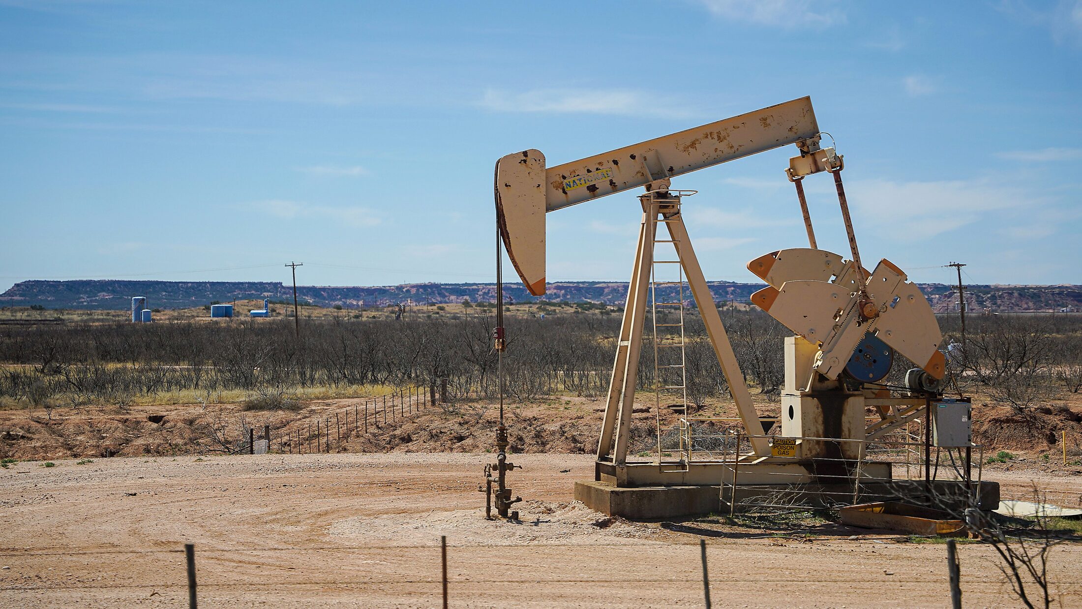 Oil pumpjack operating in a broad field landscape