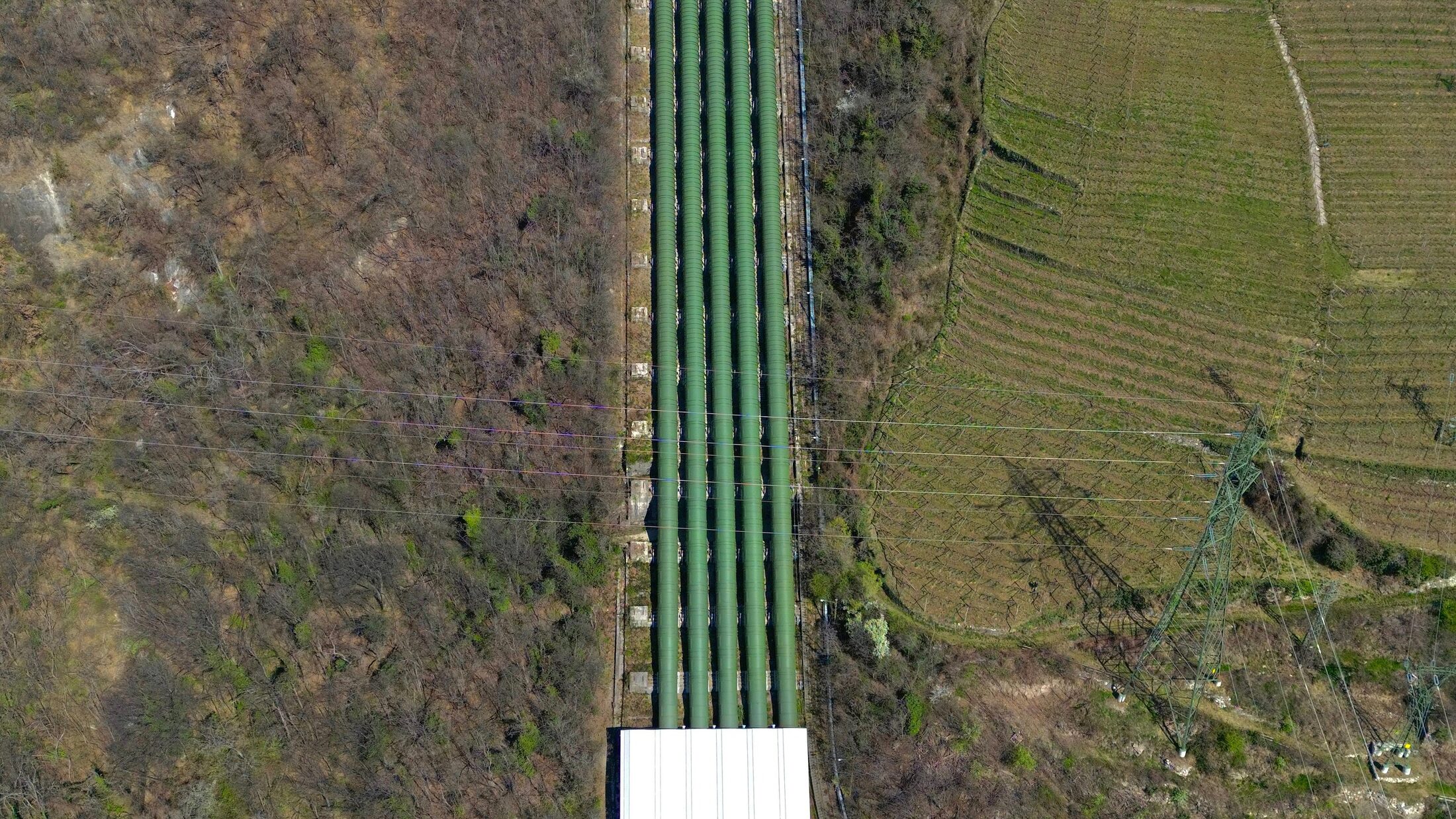 Aerial view of energy transportation infrastructure crossing a rural landscape