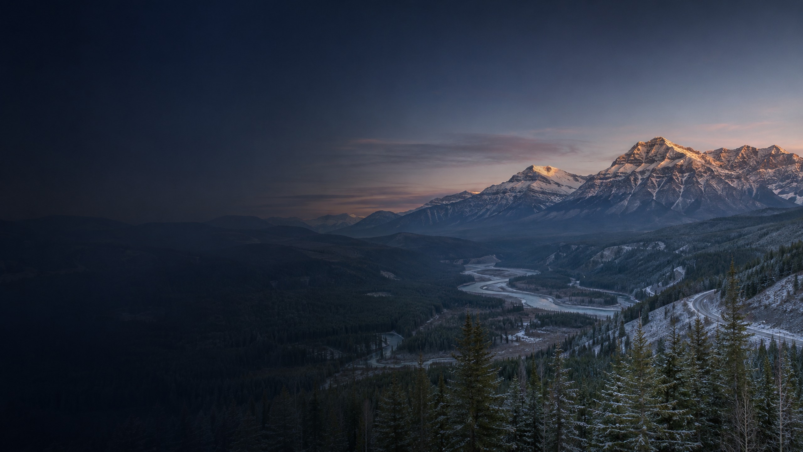 Snow-dusted Western Canadian foothills, boreal forest and river valley at dawn